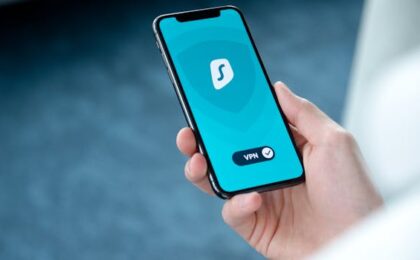 A hand holding a smartphone displaying a VPN app screen for secure online browsing.